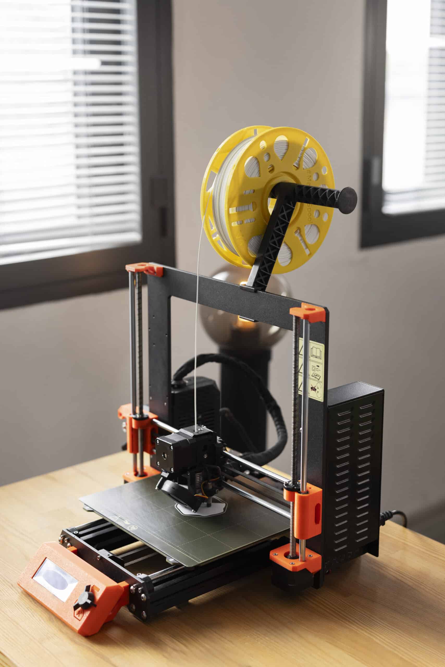Person adjusting a 3D printer's settings to fix over-extrusion and blobbing