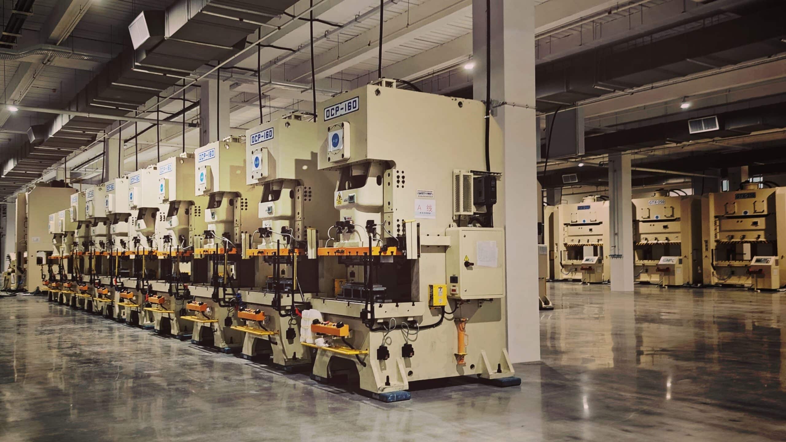 Row of industrial machines on a factory floor, representing engineering-grade manufacturing