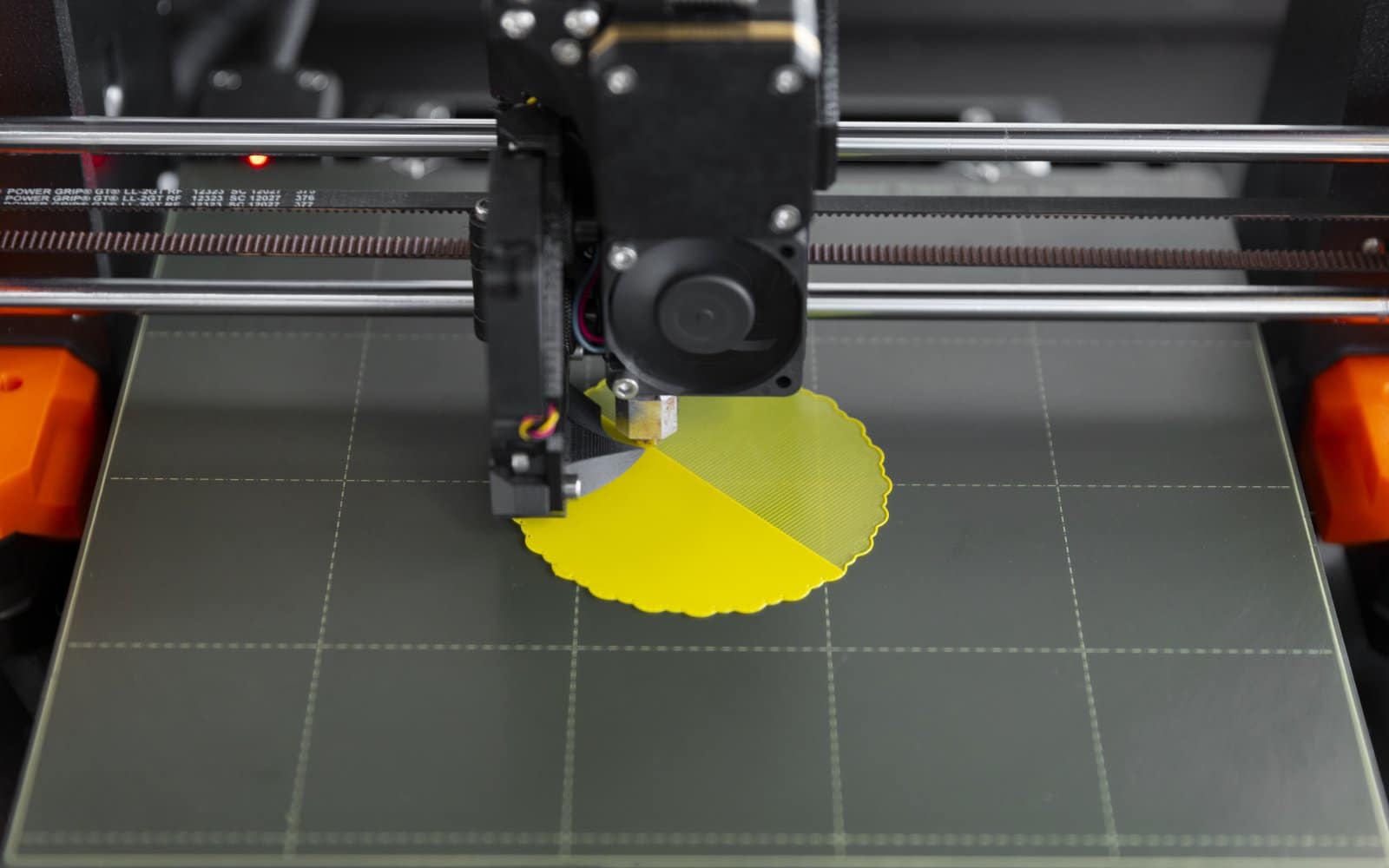 Close-up view of a 3D printer's print head and build plate