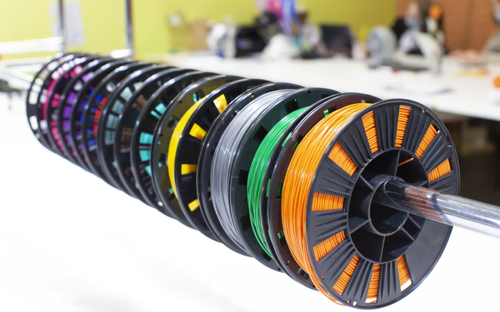 Several filament spools stored near a 3D printer