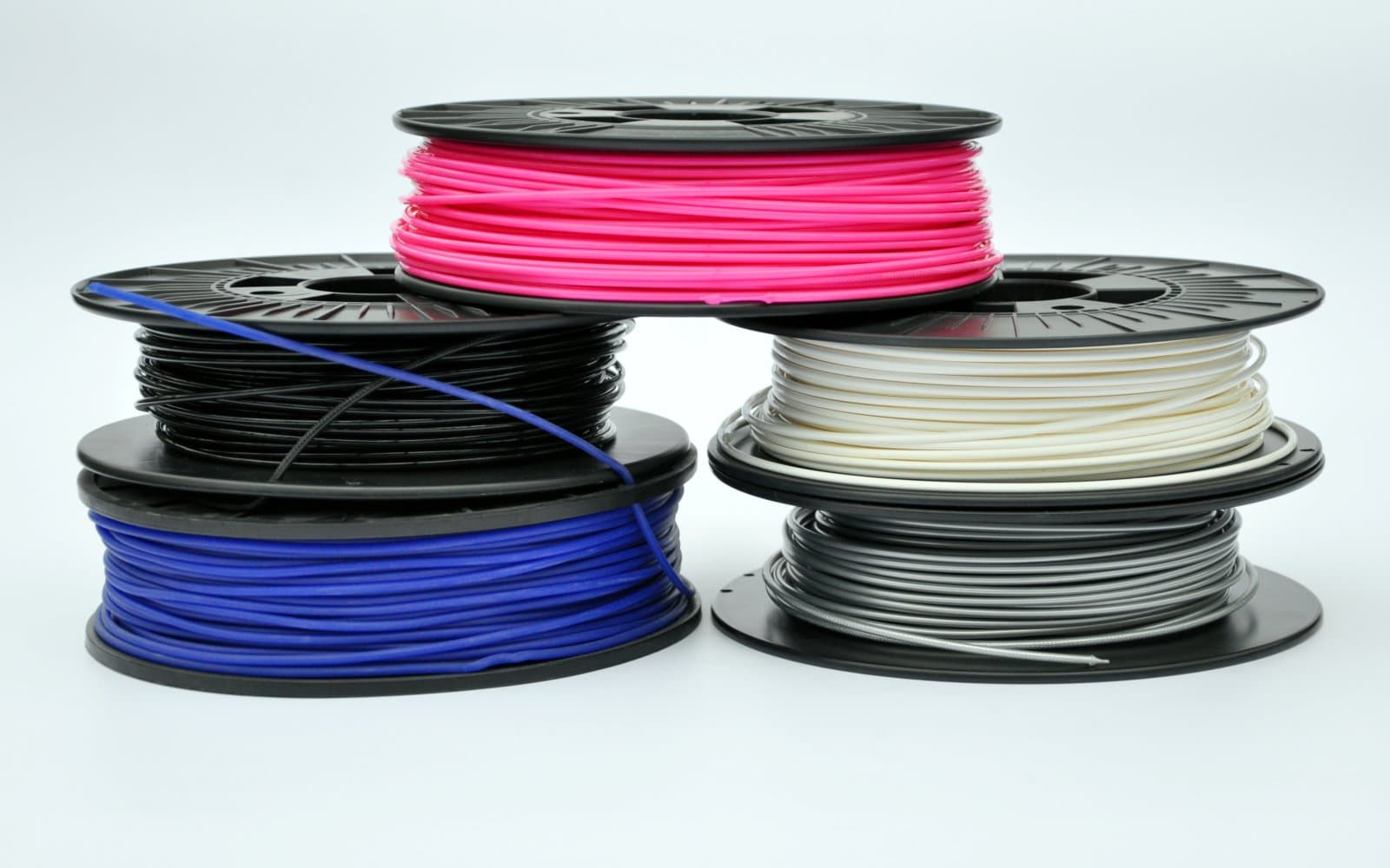 Several colorful 3D printer filament spools arranged together.