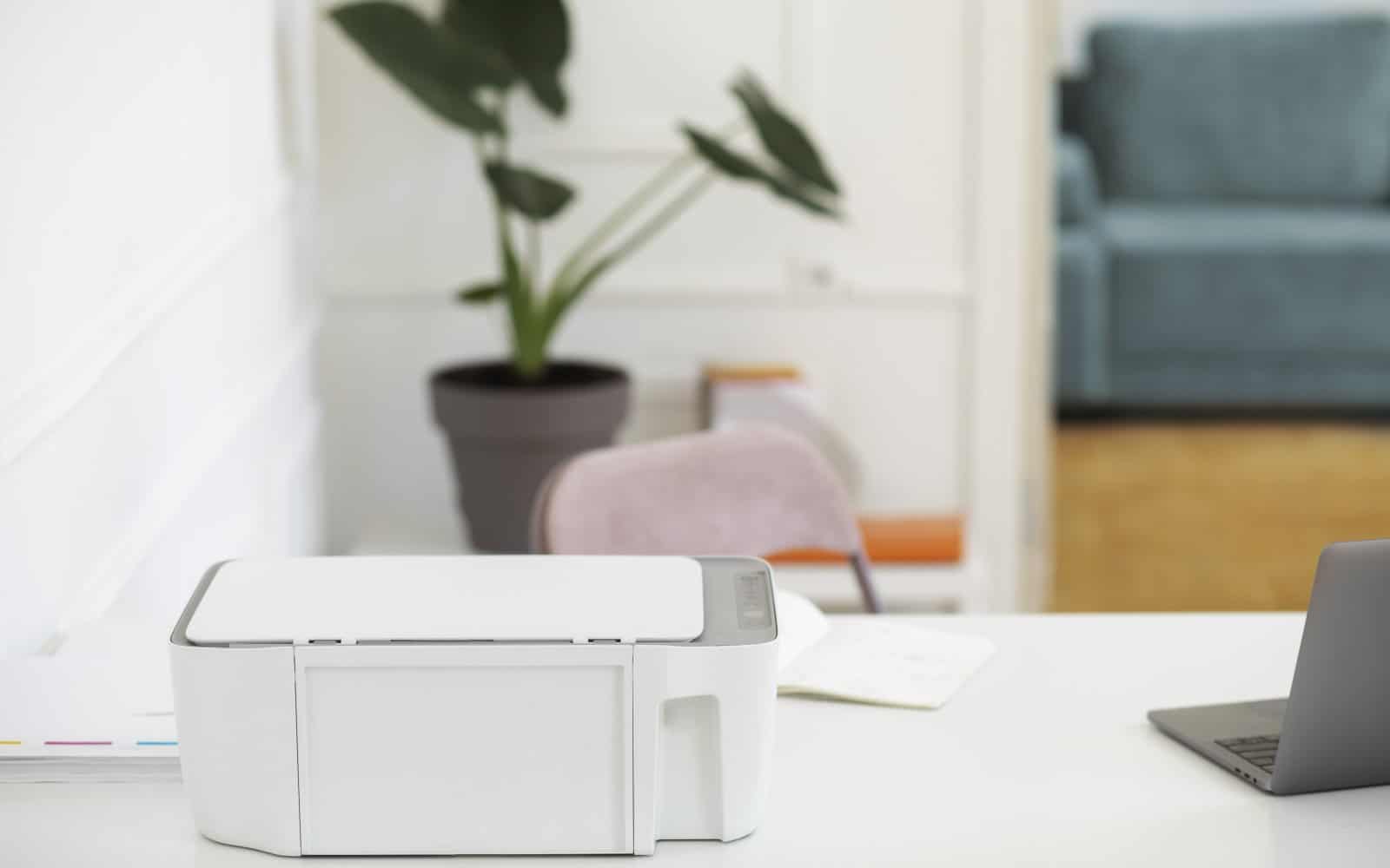 3D printer connected to a laptop on a desk, representing slicer software setup workflow.