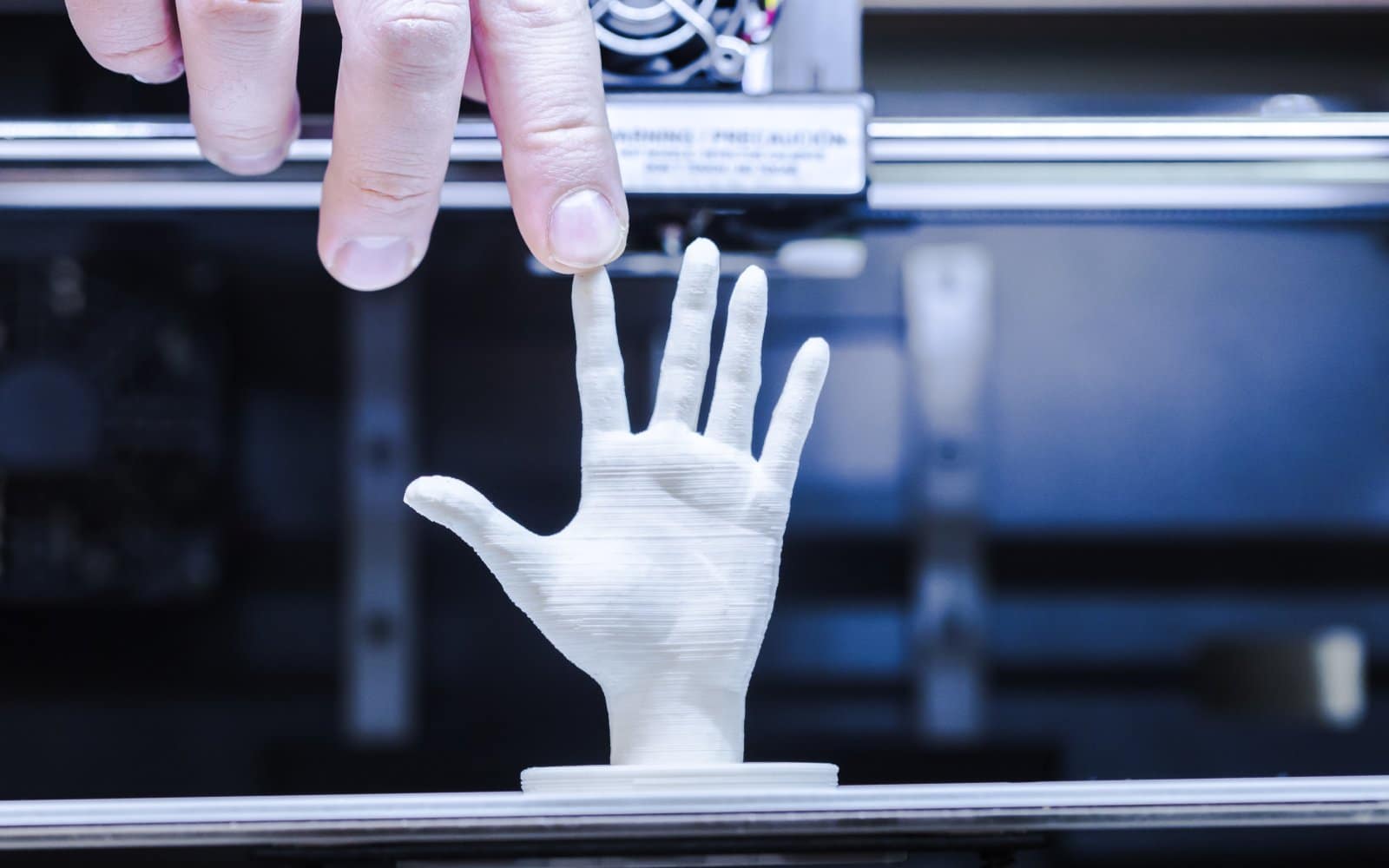 A 3D printer in the middle of printing an object, layer by layer.