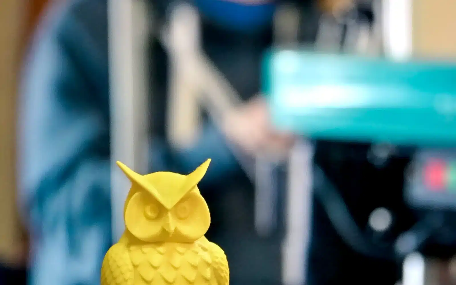 Yellow plastic object printing on an FDM printer build plate