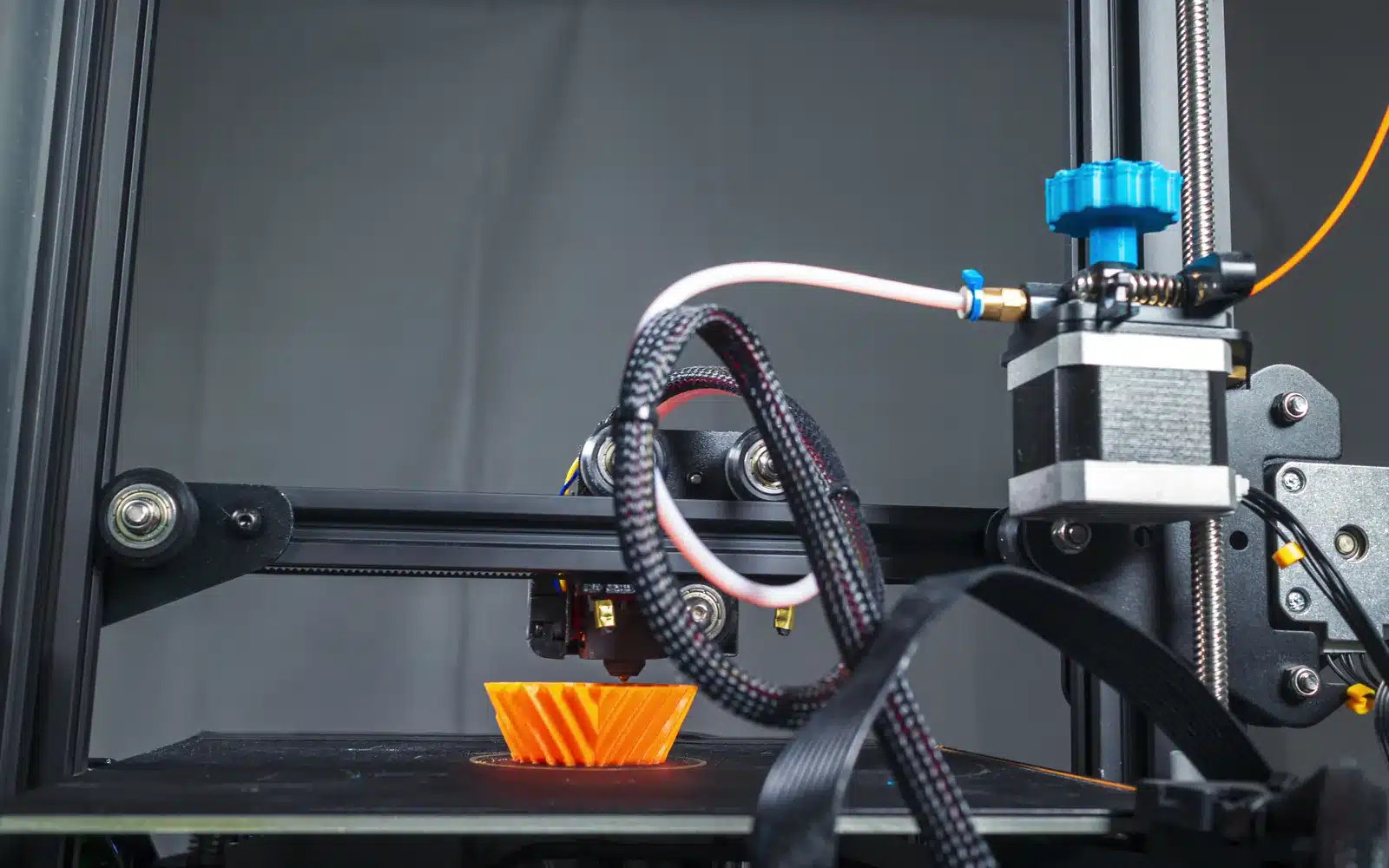 Desktop 3D printer producing a vase from filament