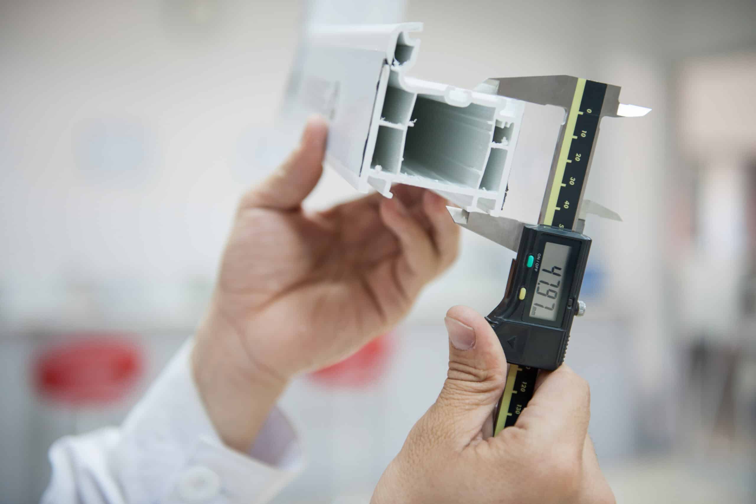 Technician measuring a plastic part with a digital caliper
