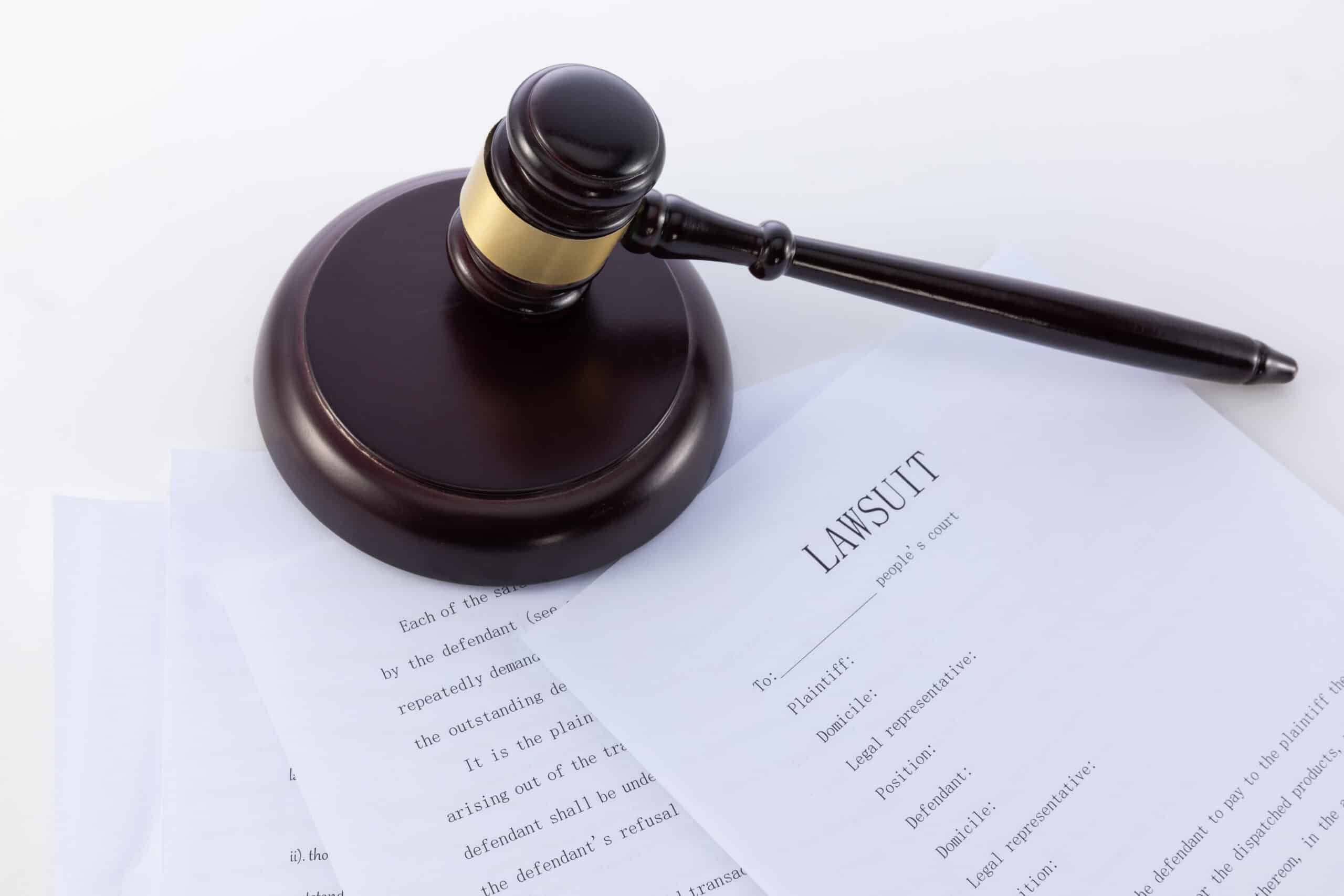 Close-up of a wooden judge's gavel resting on a printed legal document, symbolizing the Stratasys v. Bambu Lab patent lawsuit
